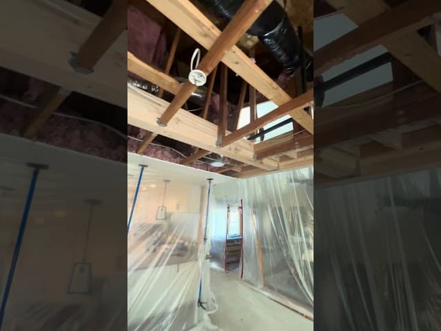 Kitchen renovation in progress showing new cabinetry installation and tile backsplash work
